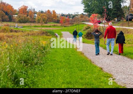 Five people and a photographer on a path at a popular tourist attraction in Plainfield Village, in Washington county, near Marshfield,Vermont, USA Stock Photo