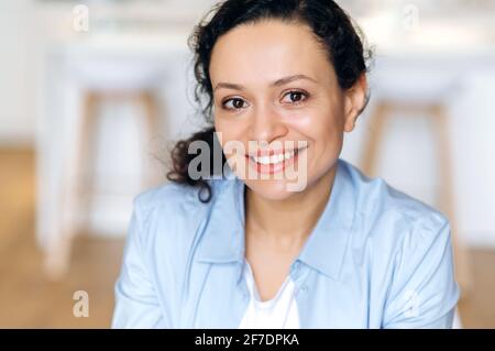Close-up portrait of an attractive happy confident adult mixed race brunette woman, business lady dressed in stylish clothes, looking at the camera, cute smiling Stock Photo