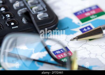 Glasses, calculator and pen lie on a newspaper. Business analytic and expertise concept. Stock Photo