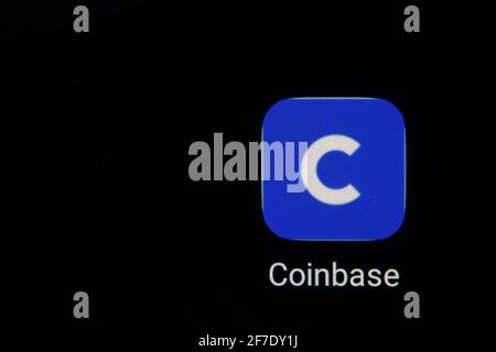 Coinbase logo on screen with Bitcoin coins. Ljubljana, Slovenia - April 06 2021 Stock Photo