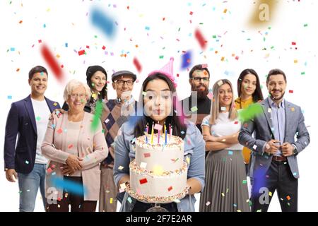 Young woman celebrating birthday and blowing candles on a cake with her family isolated on white background Stock Photo