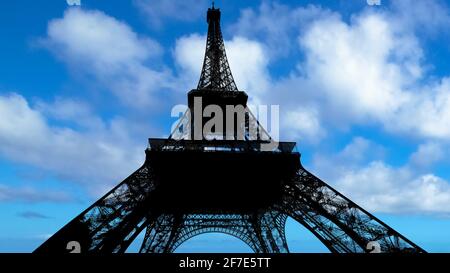 Nice clouds over blue sky on Eiffel Tower in backlight in a sunny day in Paris city of France. Stock Photo