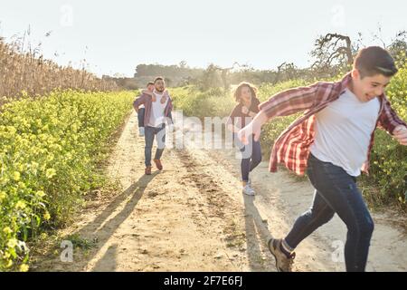 happy family runs through the countryside in spring Stock Photo