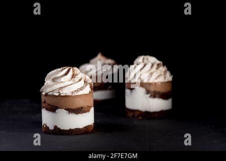 Petit fours or mini chocolate crepe cakes with chocolate on black background Stock Photo