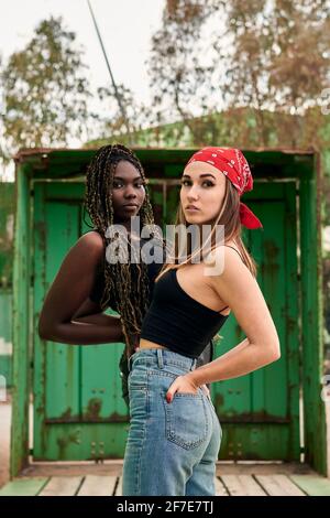 Two multiethnic women in urban clothes pose looking at the camera Stock Photo