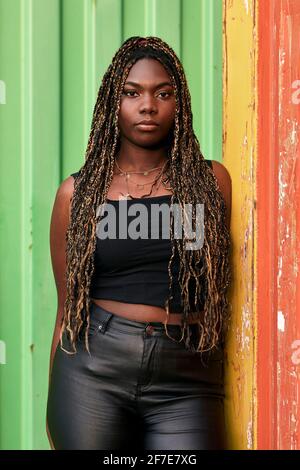 Black woman with braids and urban clothes looks serious at the camera Stock Photo