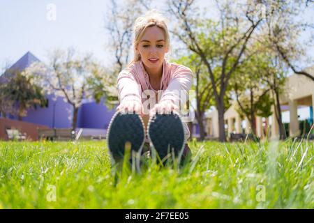 Young Woman Stretching Before Running in the Park Stock Photo