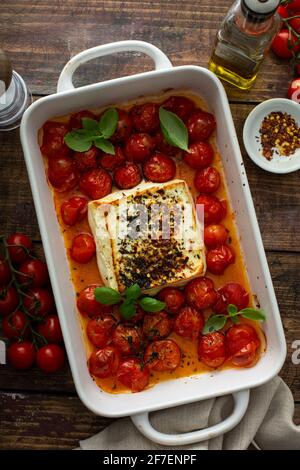 Baked feta cheese with cherry tomatoes in a pan Stock Photo