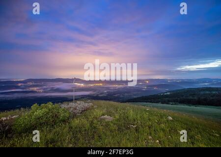Evening panorama from the hill of Vremscica, Slovenia, looking towards Koper and Trieste in rich colors of the night. Lights and clouds seen in the ba Stock Photo