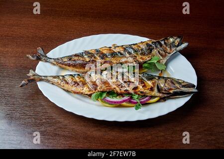 Mackerel baked on the grill lies on a white plate Stock Photo