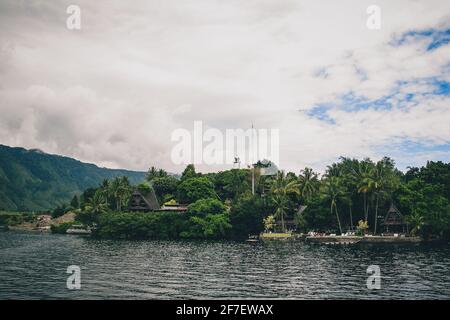 Island of Samosir on the lake of Toba, on northern Sumatra, Visible typical houses on the island on a cloudy day. Stock Photo