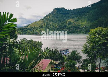 Lake Toba viewed from one of the restaurants in the city of Parapat, northern Sumatra on a cloudy day. Stock Photo