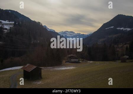 Beautiful panorama of mountains and hills while ascending to the Les Diablerets village in swiss alps. Cottage and meadow seen in the foreground. Stock Photo