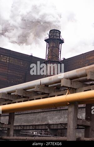  Plant pipes pollute atmosphere. Industrial factory pollution, smokestack exhaust gases.