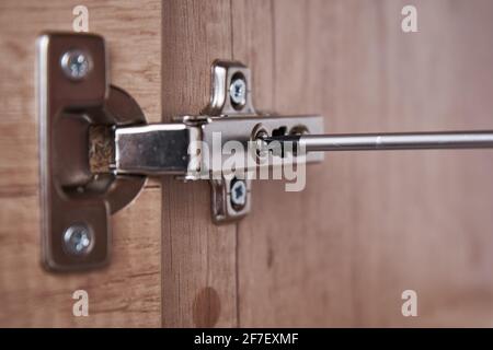 Srewdriver fixing kitchen cabinet door, close up Stock Photo