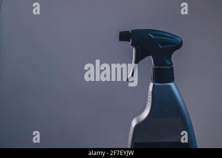 Side view of a plastic spray bottle for cleaning and operating it. Drops from bottle are being sprayed all over the place. Side view of an operational Stock Photo