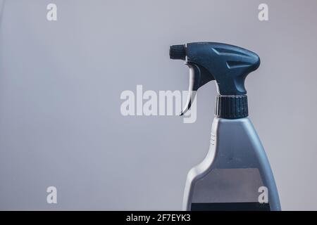 Side view of a plastic spray bottle for cleaning and operating it. Drops from bottle are being sprayed all over the place. Side view of an operational Stock Photo