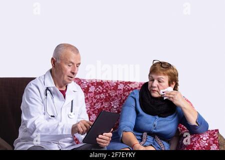 Male doctor consulting and check up information using digital tablet with senior woman at medical office. Elderly woman has sick, healthcare and Stock Photo