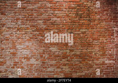 Old brick wall with visible cement stains and leftovers on the bricks. Red brick wall. Stock Photo