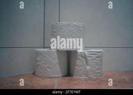 Three toilet paper rolls on a marble or granite background in a hotel bathroom. Stock Photo