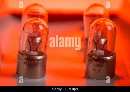 Detail of older type position lamp bulb of a car. Multitude of position lightbulbs in a bulk cardboard packaging. Stock Photo