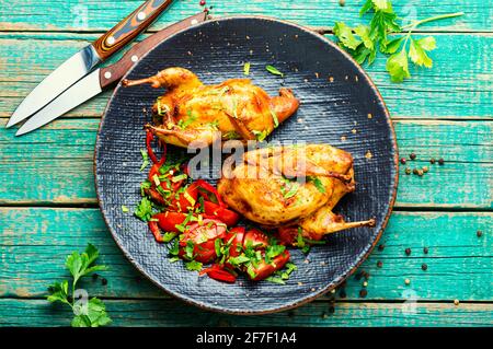 Roasted whole quail and spring vegetable salad.Appetizing baked quail meat Stock Photo