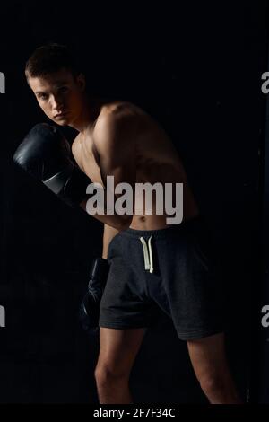 bodybuilder wearing boxing gloves black background cropped view sport fitness Stock Photo