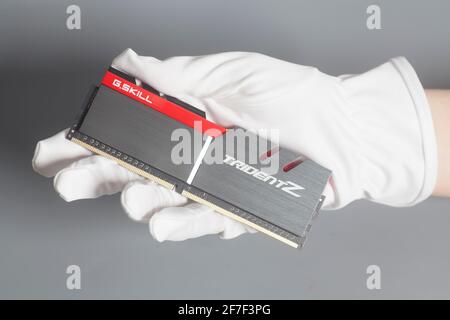 Moscow, Russia April 07,2021 Hand in white glove holding High performance DDR4 computer memory ram G.Skill Trident Z Stock Photo