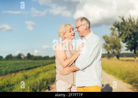 Senior couple embracing each other in love outdoors Stock Photo