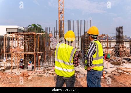 Construction civil engineer technician and architect working supervising progress of building construction project at construction site Stock Photo