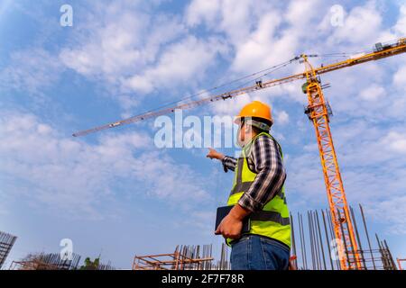 Construction engineers technician working contone crane stand in control of building foundations project at construction site Stock Photo