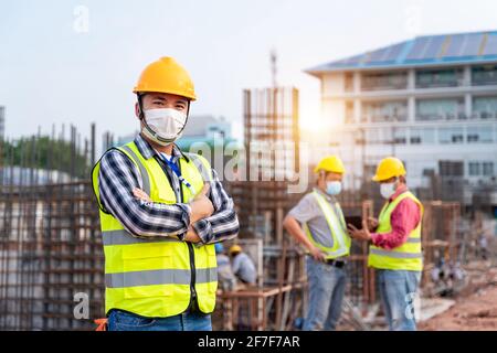 Team work of Construction engineers technician and  architect supervising progress stand in control of building foundations project at construction si Stock Photo