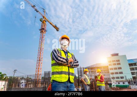 Team work of Construction engineers technician and  architect supervising progress stand in control of building foundations project and crane backgrou Stock Photo