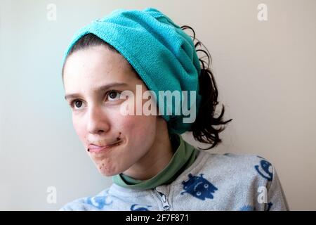 12 year-old boy licking chocolate off his upper lip Stock Photo