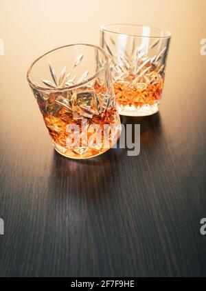 alcoholic drink, whiskey in glasses on brown wooden background Stock Photo