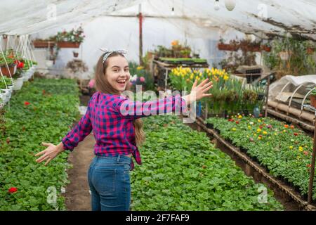 happy teen girl florist care pot plants in greenhouse, gardener Stock Photo