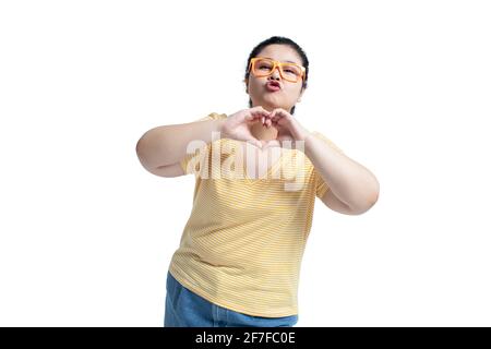Happy young woman making heart shape Stock Photo