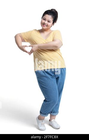 Happy young woman making heart shape Stock Photo