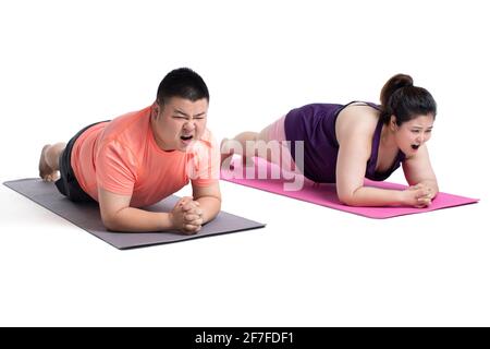 Overweight young couple doing plank position Stock Photo