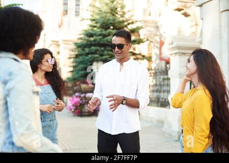 Happy multiethnic young people relax together have fun talking and chatting sharing ideas. friendship, leisure, summer and people concept. Stock Photo