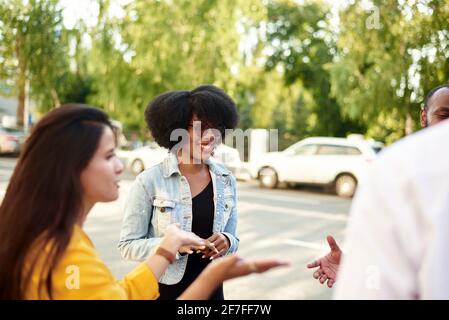 Happy multiethnic young people relax together have fun talking and chatting sharing ideas. friendship, leisure, summer and people concept. Stock Photo