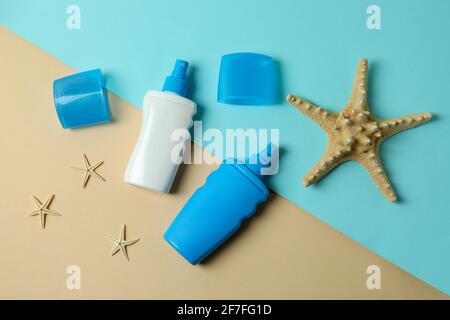 Sunscreens and starfishes on two tone background Stock Photo