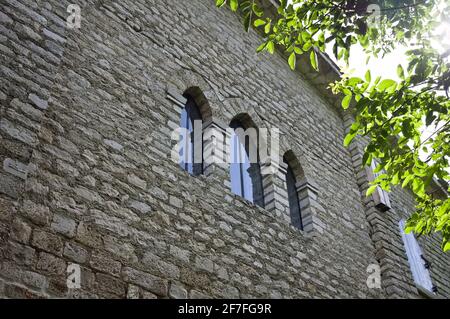 Three gothic stained glass windows in a medieval abbey with sunlight filtering through the trees (Marche, Italy, Europe) Stock Photo