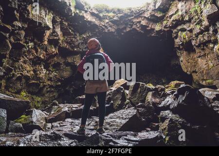 Woman traveler explore lava tunnel in Iceland. Raufarholshellir is a beautiful hidden world of cave. It is one of the longest and best-known lava