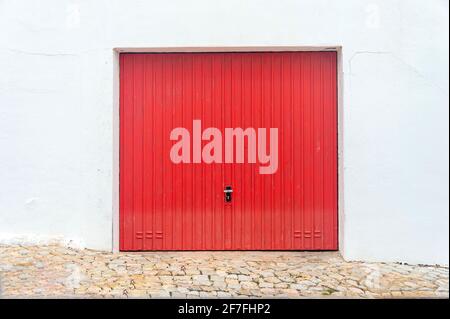 Red garage door in a white wall. Stock Photo