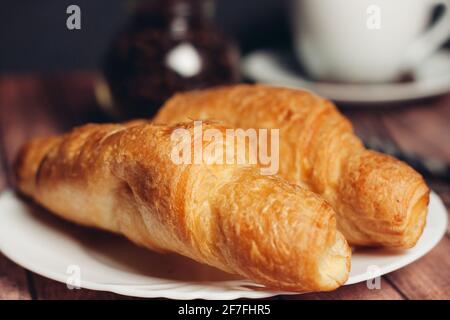 fresh croissants on a saucer table setting breakfast cup with drinks Stock Photo