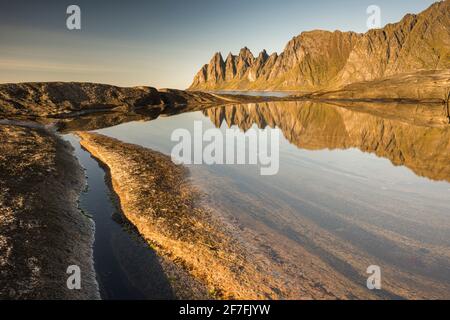 Reflection in rock pool of Devil's Teeth Mountains, from Tungenet, evening sunlight, Senja, Norway, Scandinavia, Europe Stock Photo