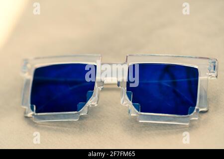Blue lenses pixel sunglasses model shoot in a summer day closeup. Selective focus Stock Photo