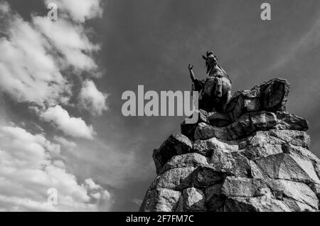 The Copper Horse statue ( of George III) at oneend of the Long Walk, Windsor Great Park, Berkshire, UK, viewed frmo below with clouds behind. B&W Stock Photo