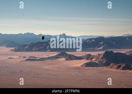 Rocky mountains, aerial view with hot air balloon flying over it, Namibia, Africa Stock Photo